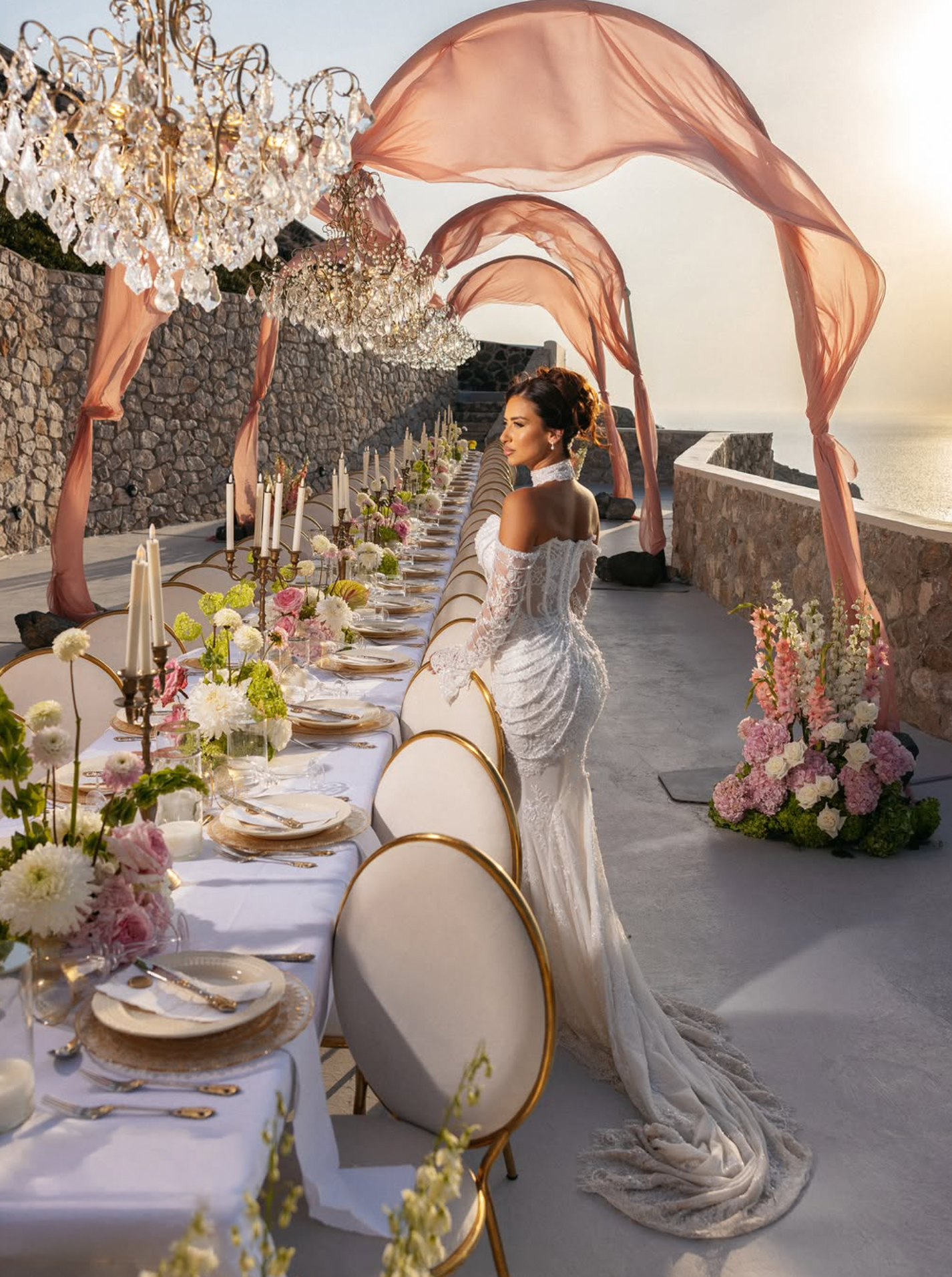 Aerial view of a couple seated among white reception tables and green hydrangeas